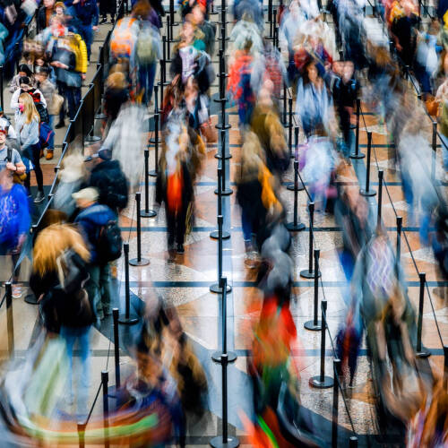 Blurry image of people waiting in a long line
